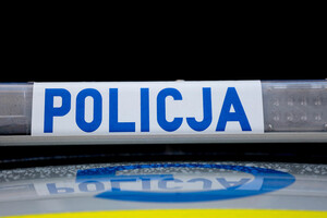 Sygnały świetlne i dźwiękowe na dachu pojazdu. Na białym tle niebieski napis Policja