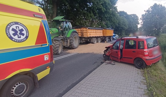 Miejsce wypadku drogowego. Samochód osobowy, ciągnik rolniczy i karetka