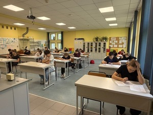 uczniowie w ławka klasowych piszą test wiedzy