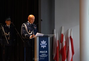 Przy mównicy Komendant Powiatowy Policji w Wadowicach. W tle policjant