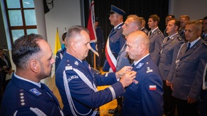 Komendant Wojewódzki przypinający medal Komendantowi Powiatowemu