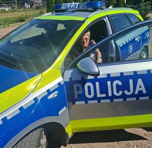 Kobieta siedząca w radiowozie na miejscu kierowcy