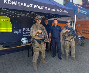 Dwóch policjantów i dwóch żołnierzy na tle namiotu