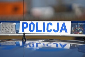 Sygnały świetlne na dachu pojazdu. Na białym tle niebieski napis Policja