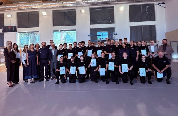 Zdjęcie grupowe, na którym są uczniowie klas policyjnych, policjant i policjantki oraz kobiety i mężczyźni w stroju cywilnym