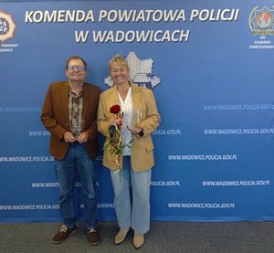 Kobieta i mężczyzna na tle policyjnego baneru