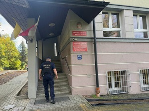 Umundurowany policjant wchodzący do szkoły w Kleczy