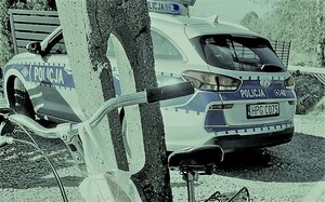 Rower oparty o słup. w tle radiowóz