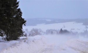 Zima, zaśnieżone drogi, w tle zabudowania