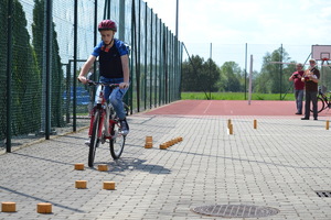 Zawodnik przejeżdża na rowerze przez slalom na torze przeszkód.