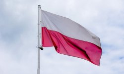 Flaga Polski w barwach biało-czerwonych, powiewająca na wietrze, na tle nieba