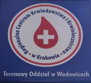 logo Regionalnego Centrum Krwiodawstwa i Krwiolecznictwa  w Krakowie , terenowy odział w Wadowicach czerwona krwinka z biały krzyżem w środku na białym tle w okręgu, główne to niebieski