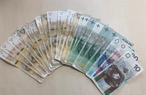 Zabezpieczone pieniądze. Rozłożone w formie wachlarza banknoty o nominalne dwieście, sto, pięćdziesiąt, dwadzieścia i dziesięć złotych.