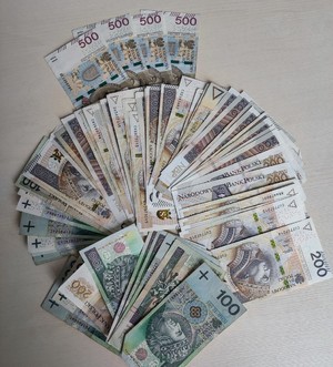 Zabezpieczona gotówka ułożona na stole w formie wachlarzy, Banknoty o nominale sto. dwieście i pięćset złotych.