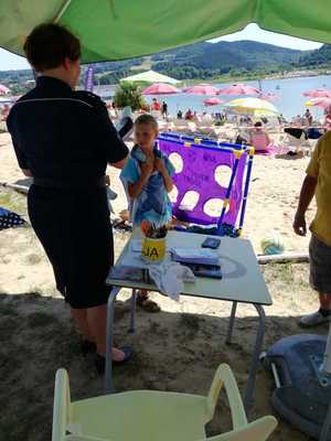 policjant soi tyłem i obserwuje dzieci na piaszczystej plaży podczas pikniku