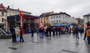 Na rynku w Wadowicach scena przed którą stoją ludzie. W tle budynki.